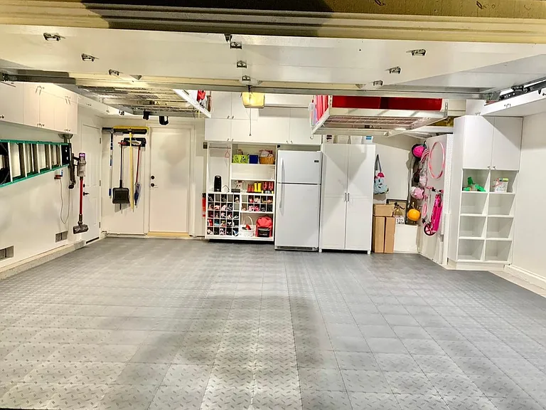 Garage with custom flooring and storage throughout.