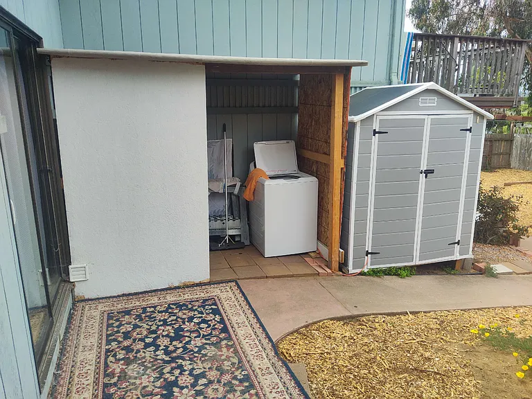 Washing machine and dryer are covered and placed in the backyard to be shared with all tenants.
