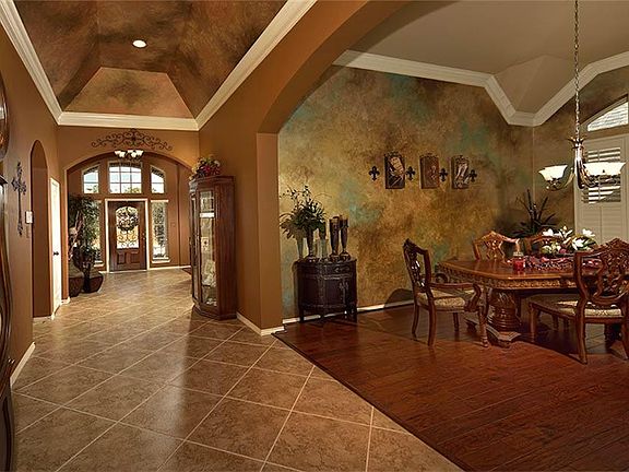 Gorgeous designer painted walls adorn ceiling and Dining Room. Wide walkway and graceful arched openings lend softness, architectural appeal, and elegance to this home.
