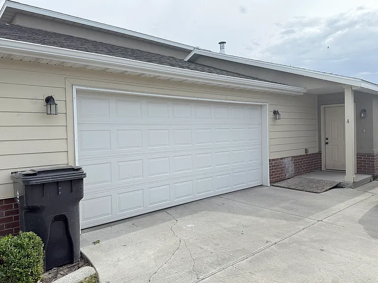 View of garage door and front entry