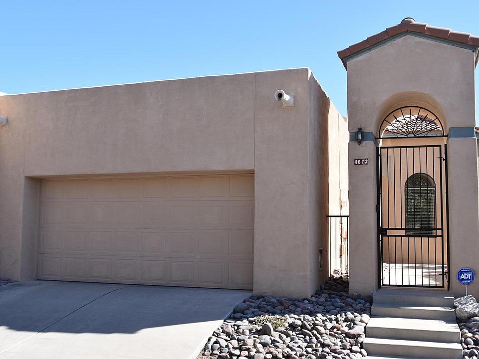 Exterior of home with locked gate and 2 gar garage