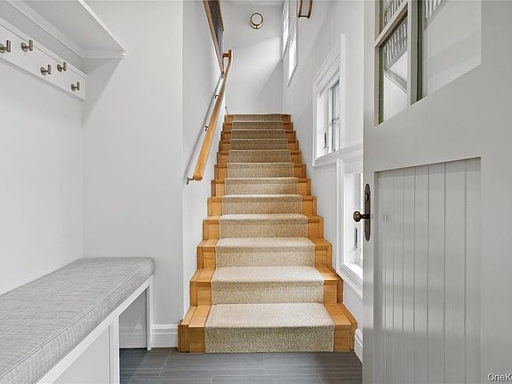 Entry with custom cabinetry, shelving and hooks. Freshly shampooed carpet runner.