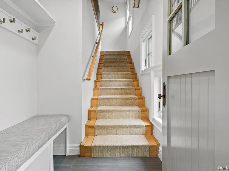 Entry with custom cabinetry, shelving and hooks. Freshly shampooed carpet runner.