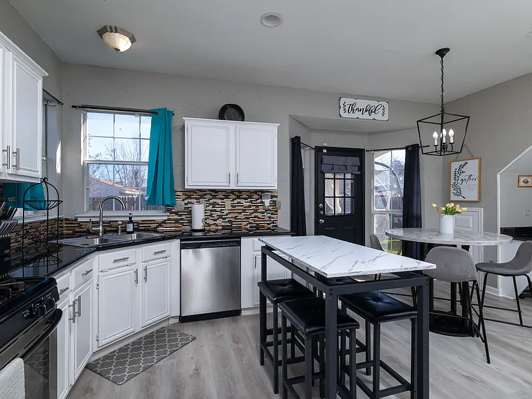Bright, modern kitchen with a sleek island and cozy dining area.