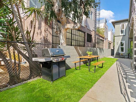 Side yard with picnic table and grill is a shared space.