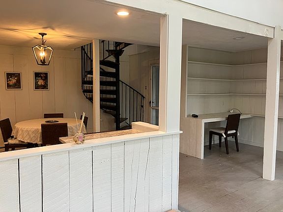 Dining area with spiral staircase to loft bedroom Built in desk area