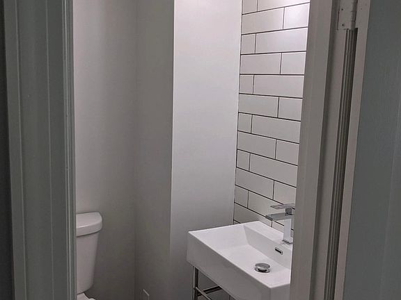 Powder room with stylish tiled walls and floor