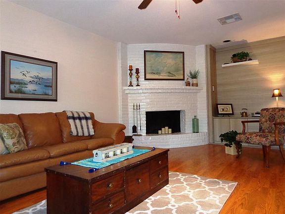Cozy up to the fireplace this winter. Another view of the spacious family room showing more custom storage with bookcases by the fireplace.