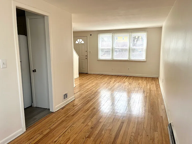 Bright and spacious living room with new windows and hardwood floor.