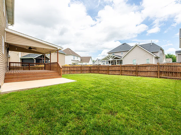 Relax in a fully fenced-in backyard designed for entertaining. The upper deck steps down to a dedicated concrete pad perfect for grilling. Unwind in the evening under the cozy string lighting or watch the game on the outdoor tv
