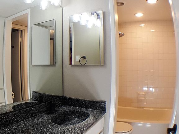 Guest Bath. Features: oil rubbed bronze light fixture with Edison style LED bulbs. Fountain style faucet. Towel ring and robe hook. The wall adjacent to the vanity is all storage space.