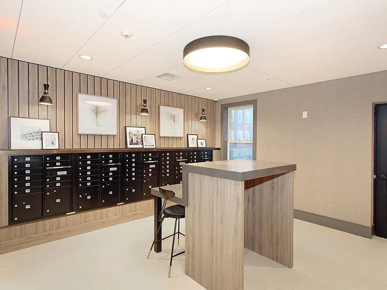 Modern lobby area with featuring Luxer One package delivery system and secure mailboxes, offering a welcoming and elegant entrance.