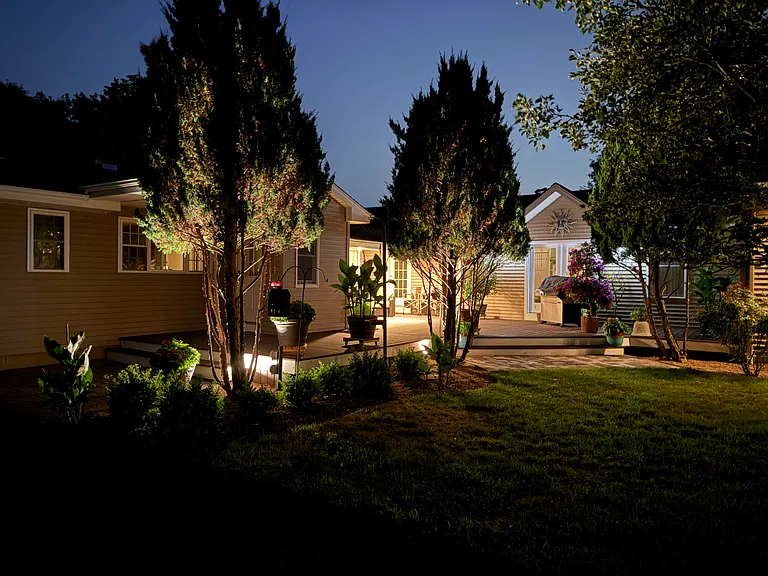 Evening view of the home and illuminated outdoor areas