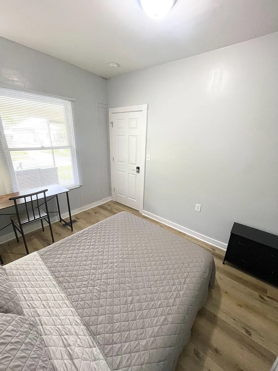 Photo 2 of 6 - N Gladstone Ave - Indianapolis, IN Private bedroom with a large window, wood-style flooring, and space for a bed plus a desk or dresser. - N Gladstone Ave