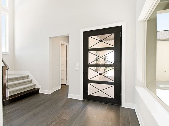 Elegant wood and glass front door and wood flooring at foyer
