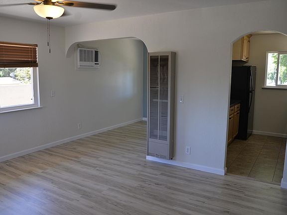 From the front door. AC unit, heater in photo. Balcony through the window. Kitchen to the right. Flooring is new. Ceiling texture is new.