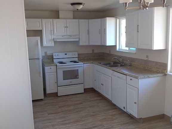 Open kitchen with dishwasher, range, refer, and range hood.