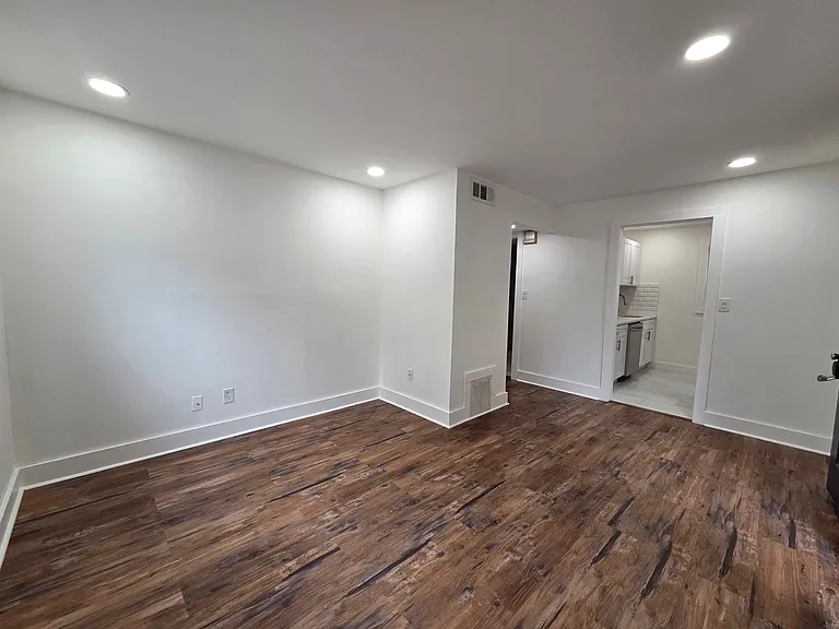 Inviting living space with elegant wood flooring and modern recessed lighting leading to a sleek kitchen area. Inviting living space with elegant wood flooring and modern recessed lighting leading to a sleek kitchen area.