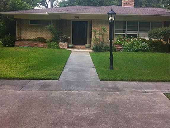 New front door, tiled porch and planters. Sprinkler system waters and beds and approximately 6 feet 