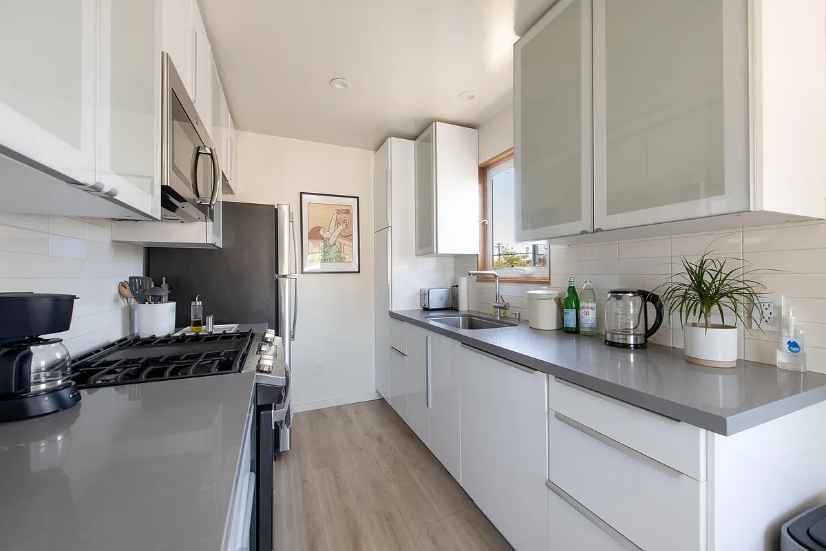 A kitchen equipped with modern appliances (including a dishwasher) and plenty of storage space! - 2136 Curtis St #A