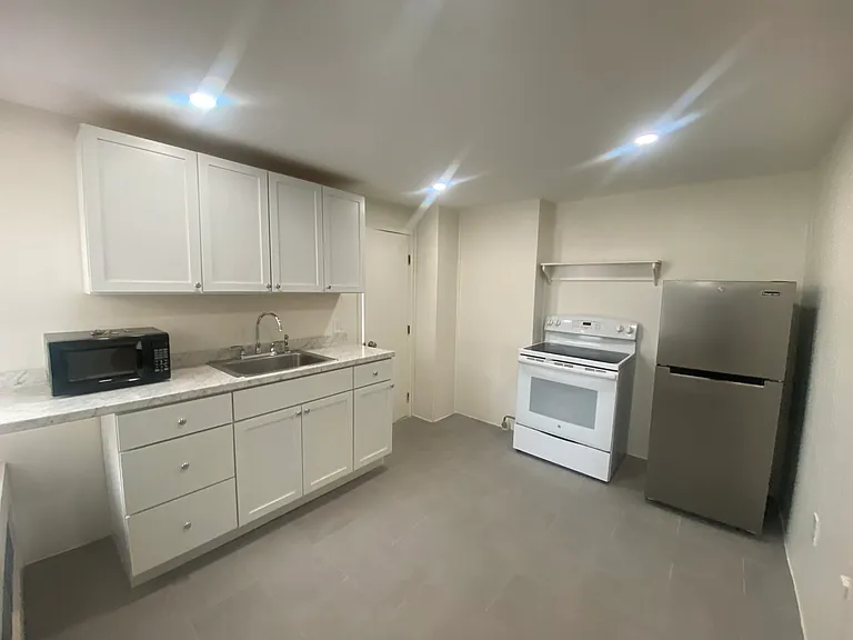 Kitchen has new cabinets and tiled flooring
