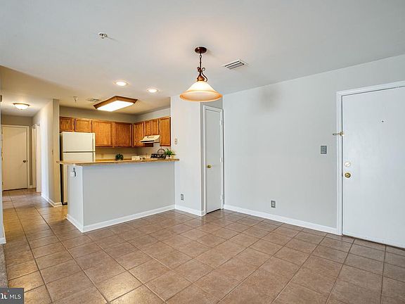 Tiled dining area with bar over-hang; coat closet