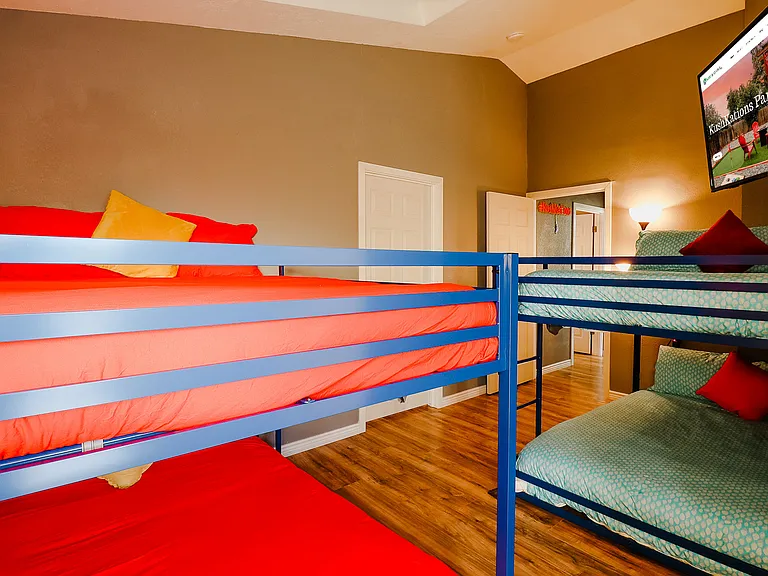 A bunk bedroom that cleverly maximizes space, offering a cozy and functional sleeping solution for multiple occupants, ideal for siblings or guests.