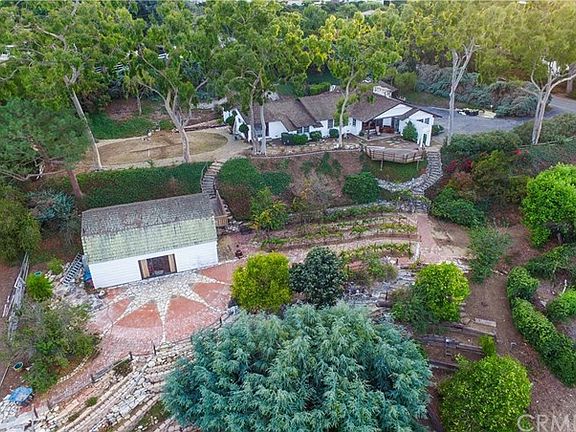 Aerial view of the property showing barn to the left and home top right - multiple pads of usable land with terraces, orchards, vineyard with room for pool or other improvements.