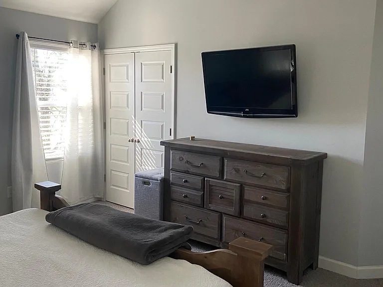 Master bedroom with mounted TV, complete with Apple TV box