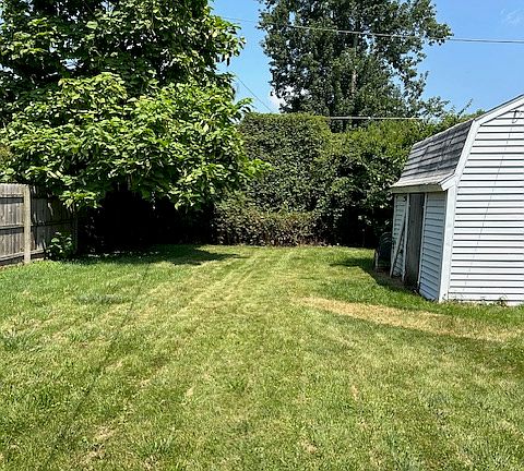 view of fenced in back yard with shed
