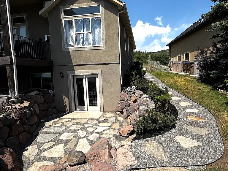 Pathway to private entrance. Enjoy the privacy of your own beautifully finished 976-sf walkout apartment, complete with stunning mountain views, garage and private exterior entrances, all utilities, cable, and high-speed internet included.