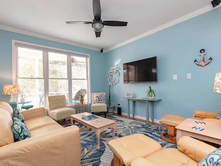 The family room boasts an open floor plan, plenty of seating, a ceiling fan, and lots of natural light.