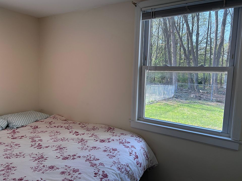 Sleeping Area with Queen Bed next to windows with natural light