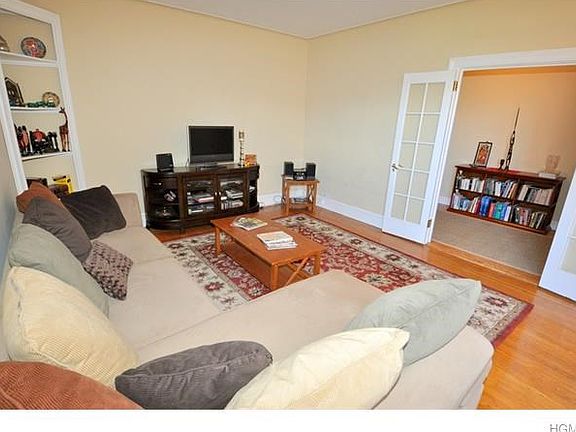 Large living room has in-layed hardwood floors and French doors leading to the large entry foyer.  The room is 21'-0" x 13'-0".