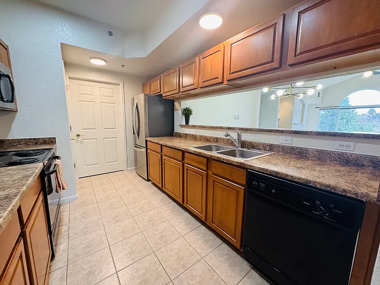 The kitchen boosts solid wood cabinetry, black and stainless steel appliances (including a new fridge and microwave).