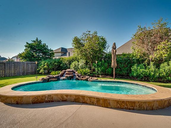 Beautifully landscaped backyard with gas heated pool and waterfall.