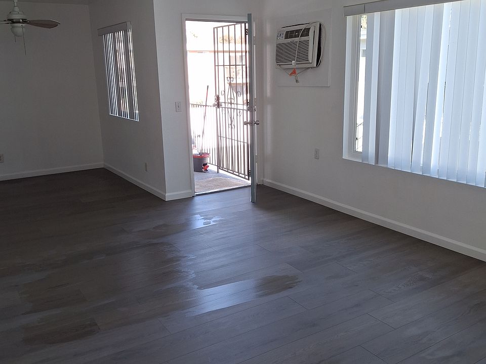 Entryway and living room showing partially kitchen eating area as well as the wall air conditioning unit