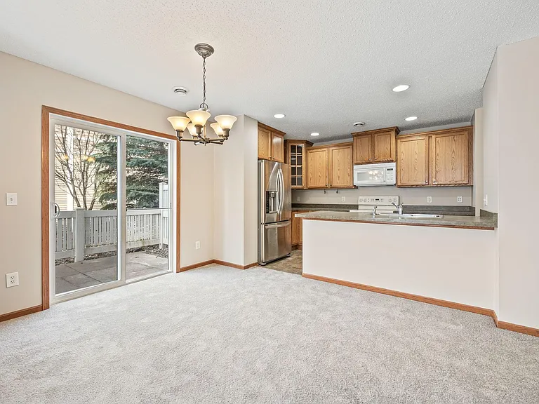 Patio/sideyard door and Kitchen. Stainless steel Refrigerator and Dishwasher.