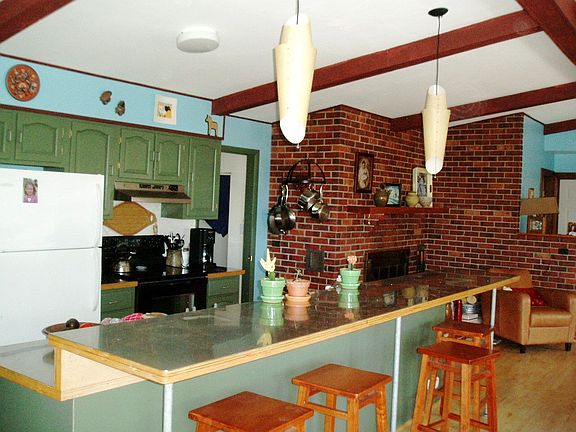 Kitchen has a great stainless island, new appliances, and cozy fireplace.