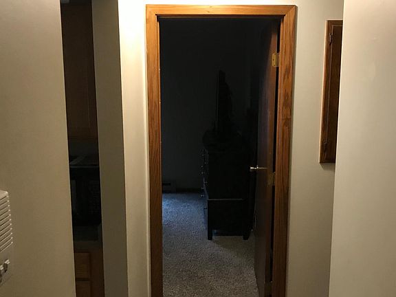 Hallway (view from living room) leading to bedroom 1 (straight ahead) and bathroom and bedroom 2 (to right). Doorway to left is kitchen.