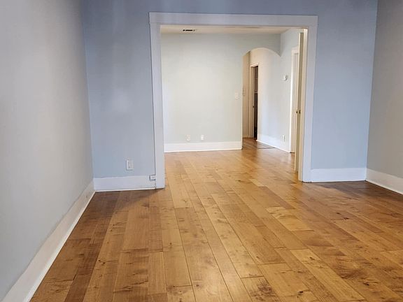 This view shows the living room, dining room and original arch into the kitchen.