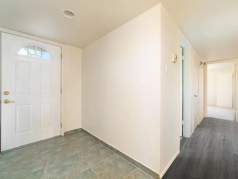 Front door entry and hallway leading to the bedrooms and bathrooms.