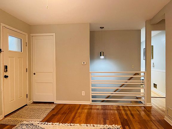 Front entryway, closet and railing to stairway