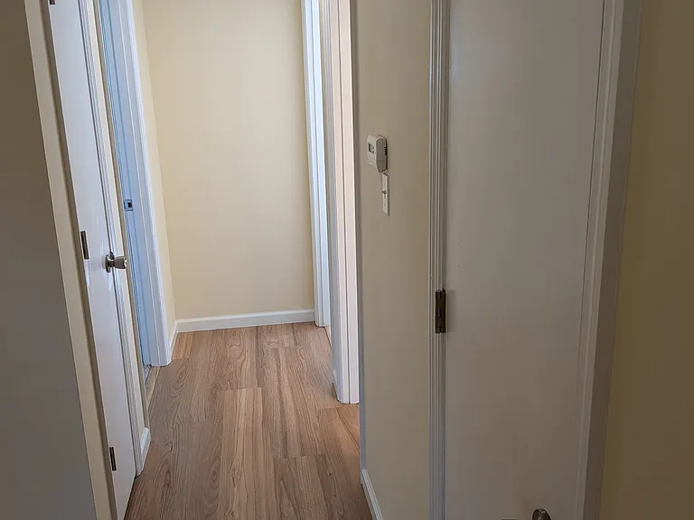 Hallway (on right is first bedroom, bathroom and coat closet and on left is second bedroom and linen closet). View from living room