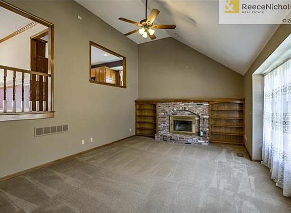Spacious great room with brick fireplace flanked by book shelves