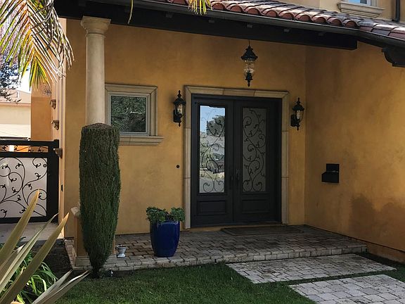 Home features front and gated backyard with fountain.