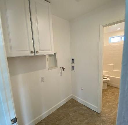 Laundry room w Hookups for stackable washer & dryer. Full bathroom in background