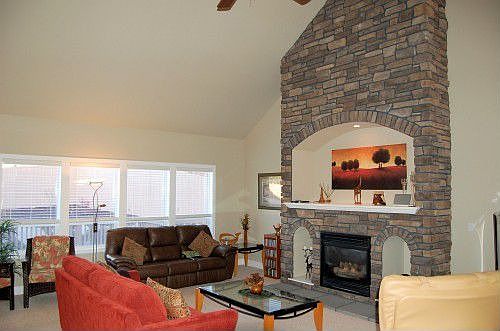 Floor to ceiling stone fireplace with natural gas insert and built-in entertainment center.