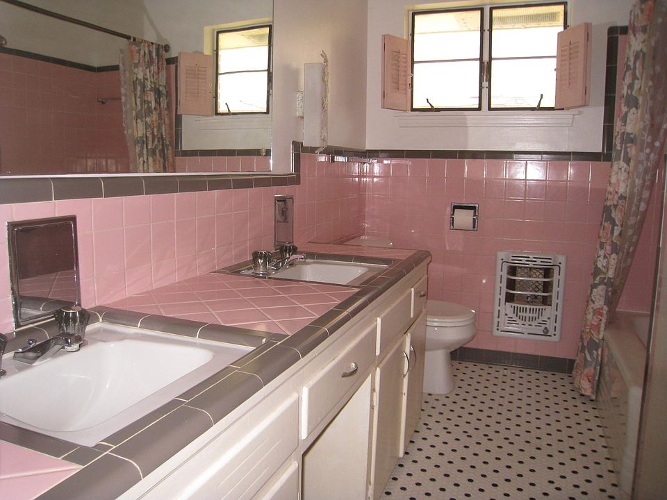 2-sink bathroom with original pink wall tile and counter. New b&w tile floor.