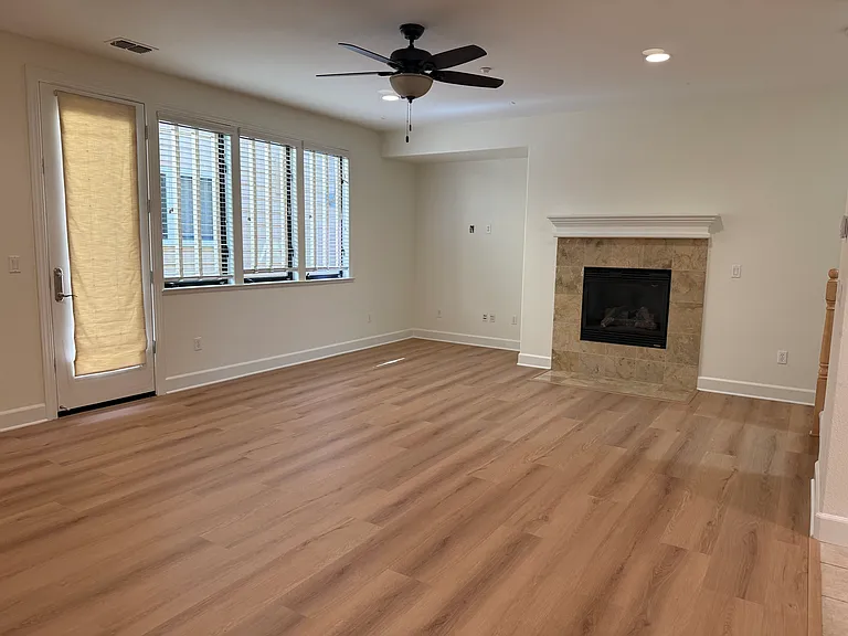 Spacious family room features a gas fireplace, large windows, ceiling fan and a glass patio door that opens to a relaxing private side patio.